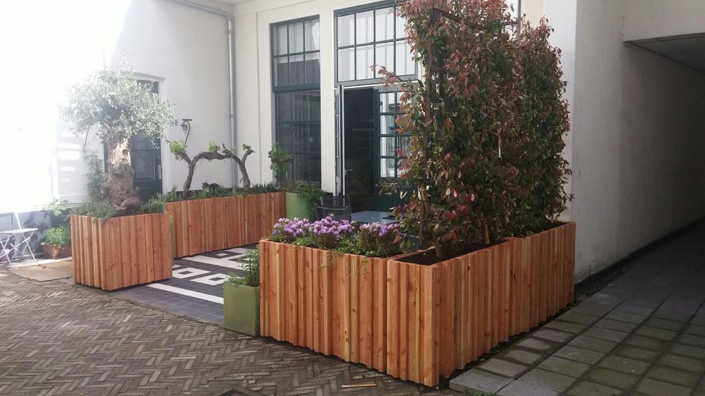 Grote houten plantenbakken in cederhout op een binnenplaats