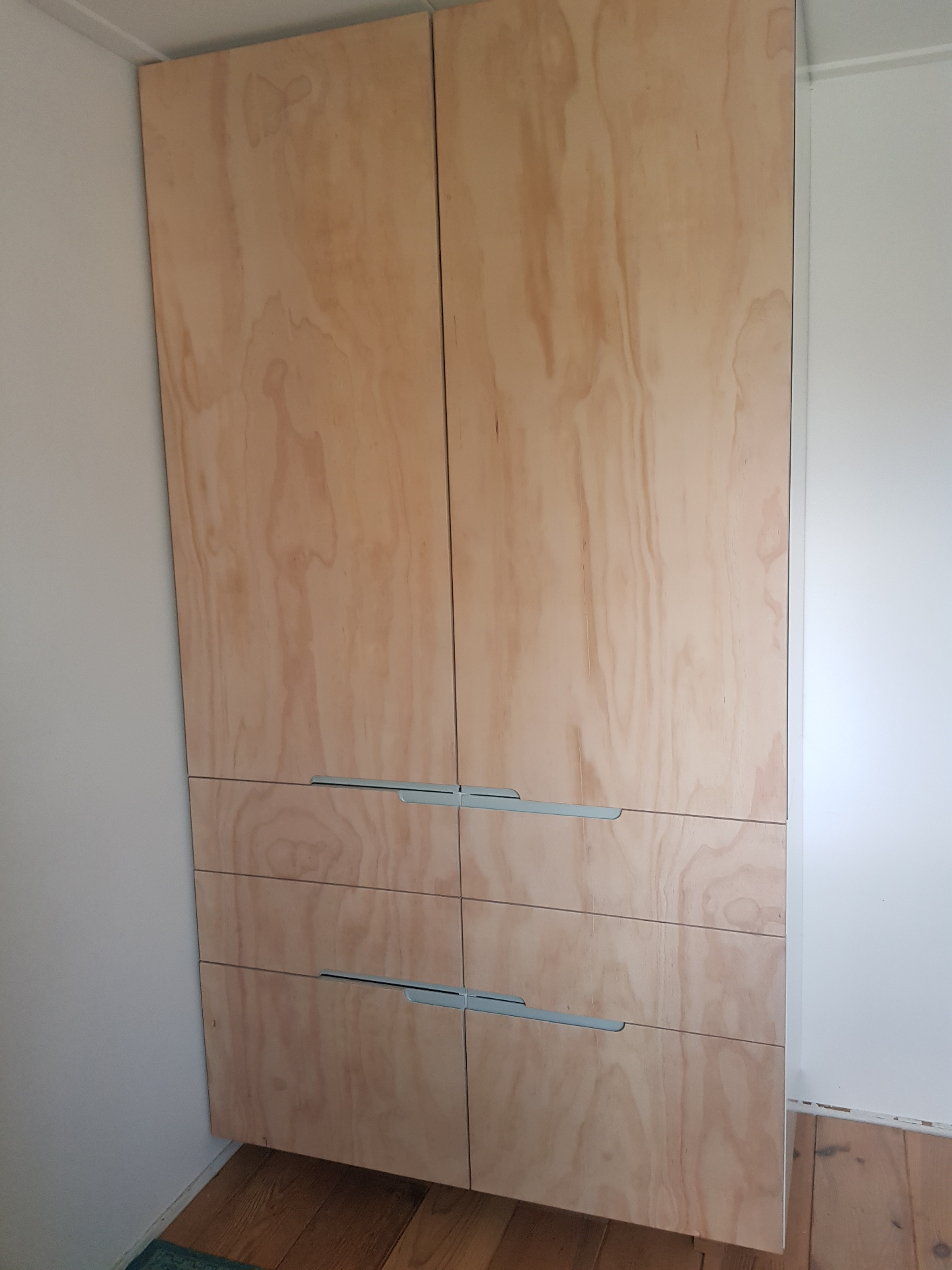 Hoge multiplex kast met lades en verzonken metalen grepen